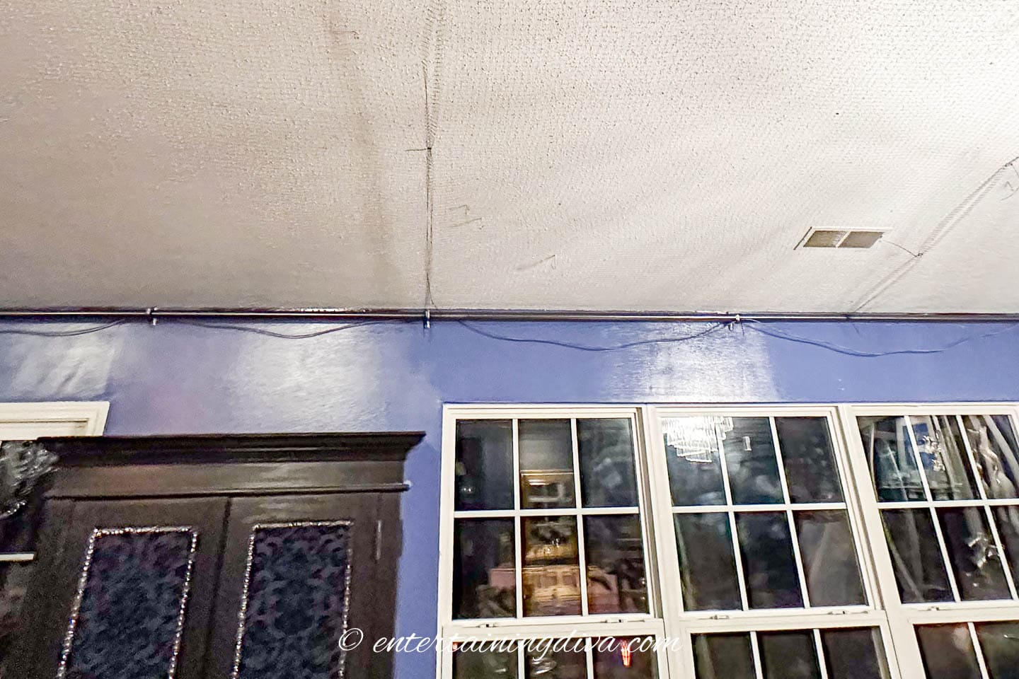 A curtain rod installed at the top of the wall with black mesh attached to it