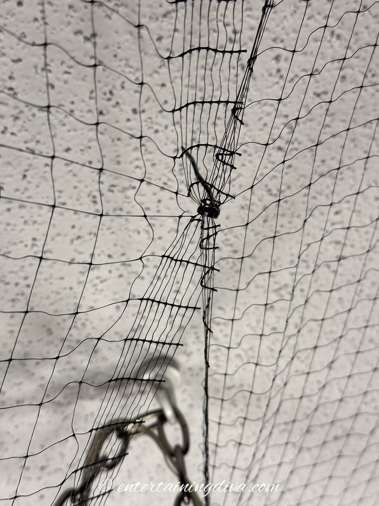 Zip tie holding 2 panels of black mesh together