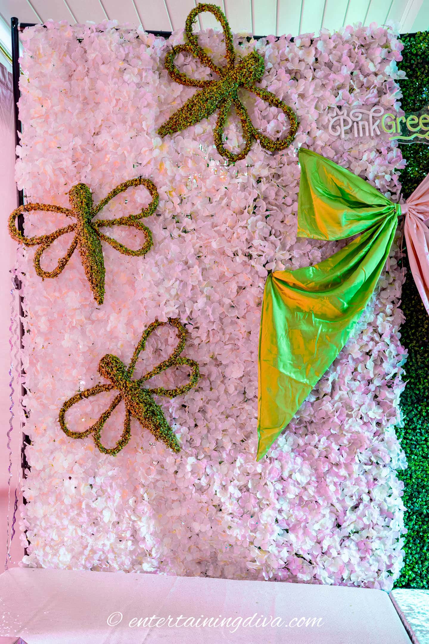 Large green dragonflies on a pink flower backdrop