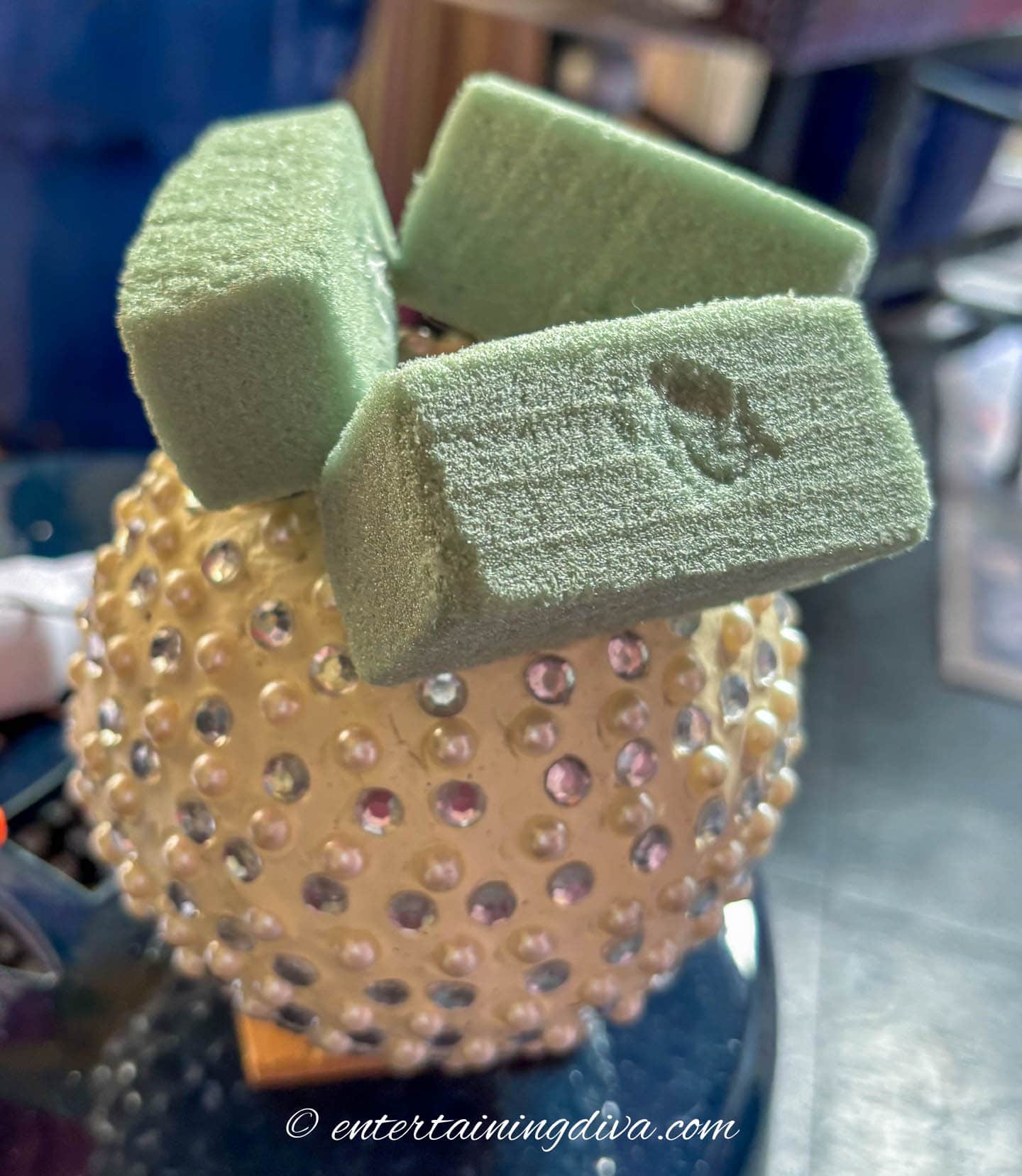 A large ornament with 3 pieces of floral foam stuck to it