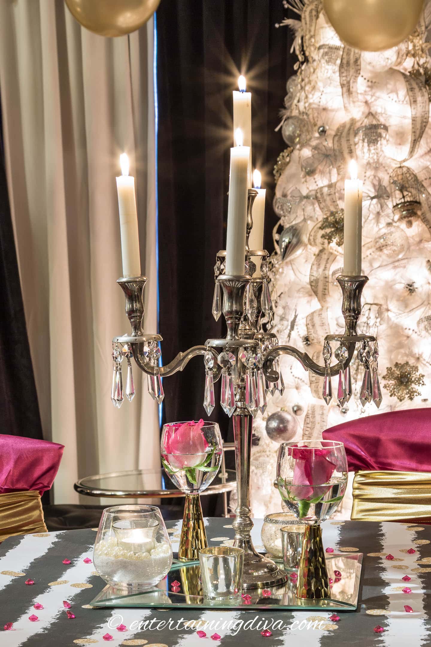 A tall candelabra with tealight candles around it on a mirror charger