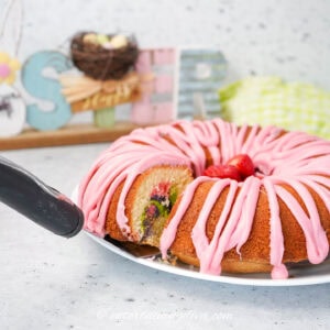 A side view of a slice being removed from a pastel swirled bundt cake