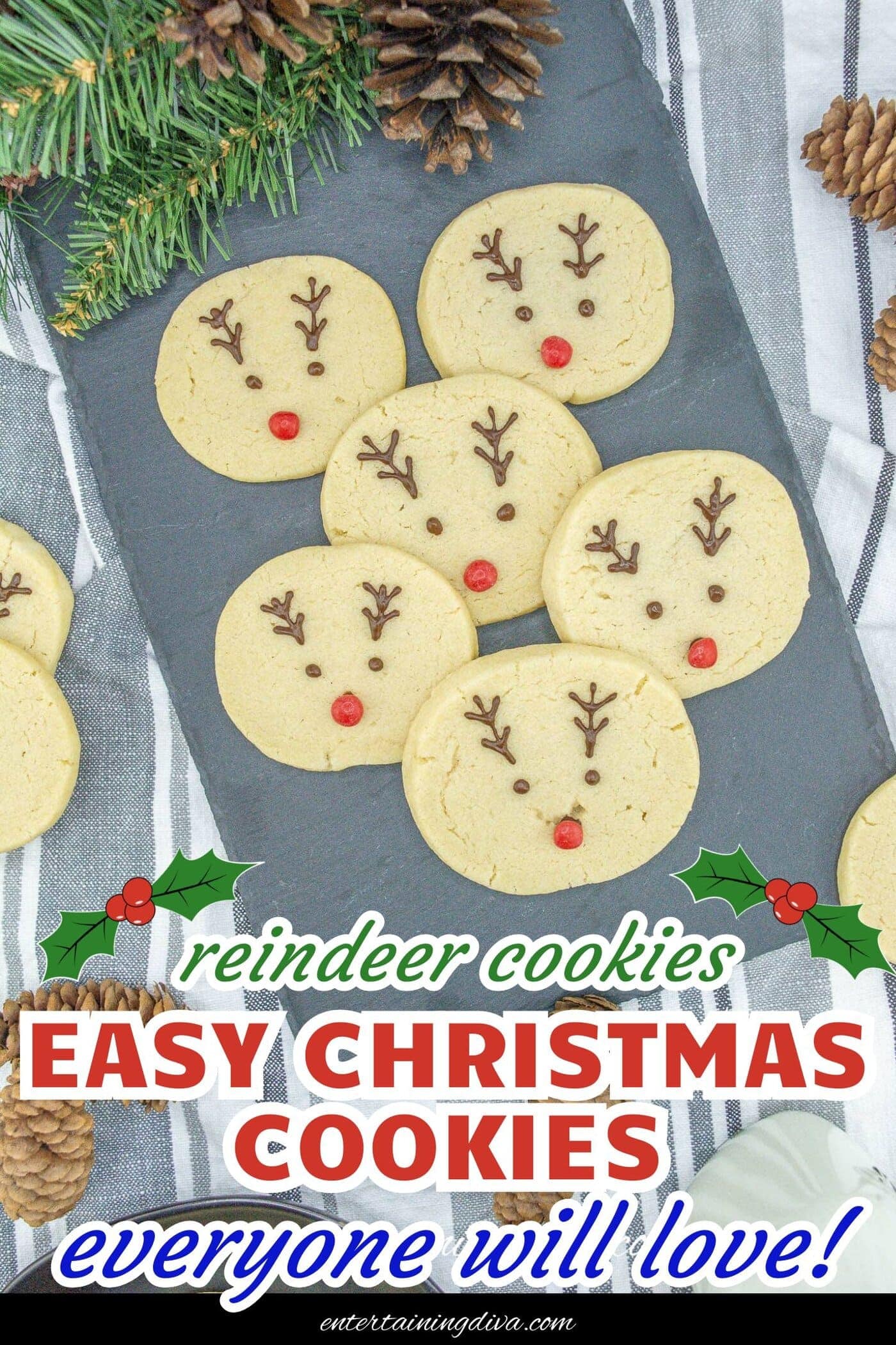 Reindeer sugar cookies and pine cones displayed on a slate.