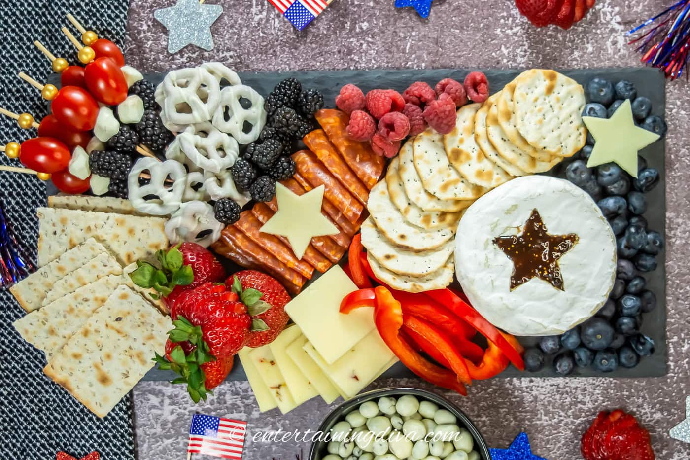 A red, white and blue 4th of July charcuterie board decorated with white stars cut from cheese