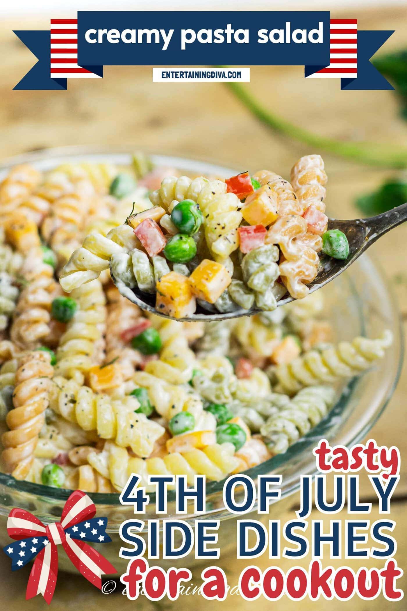 A close-up of a spoonful of tri-color rotini pasta salad with diced vegetables and peas, held over a glass bowl filled with more of the same salad.