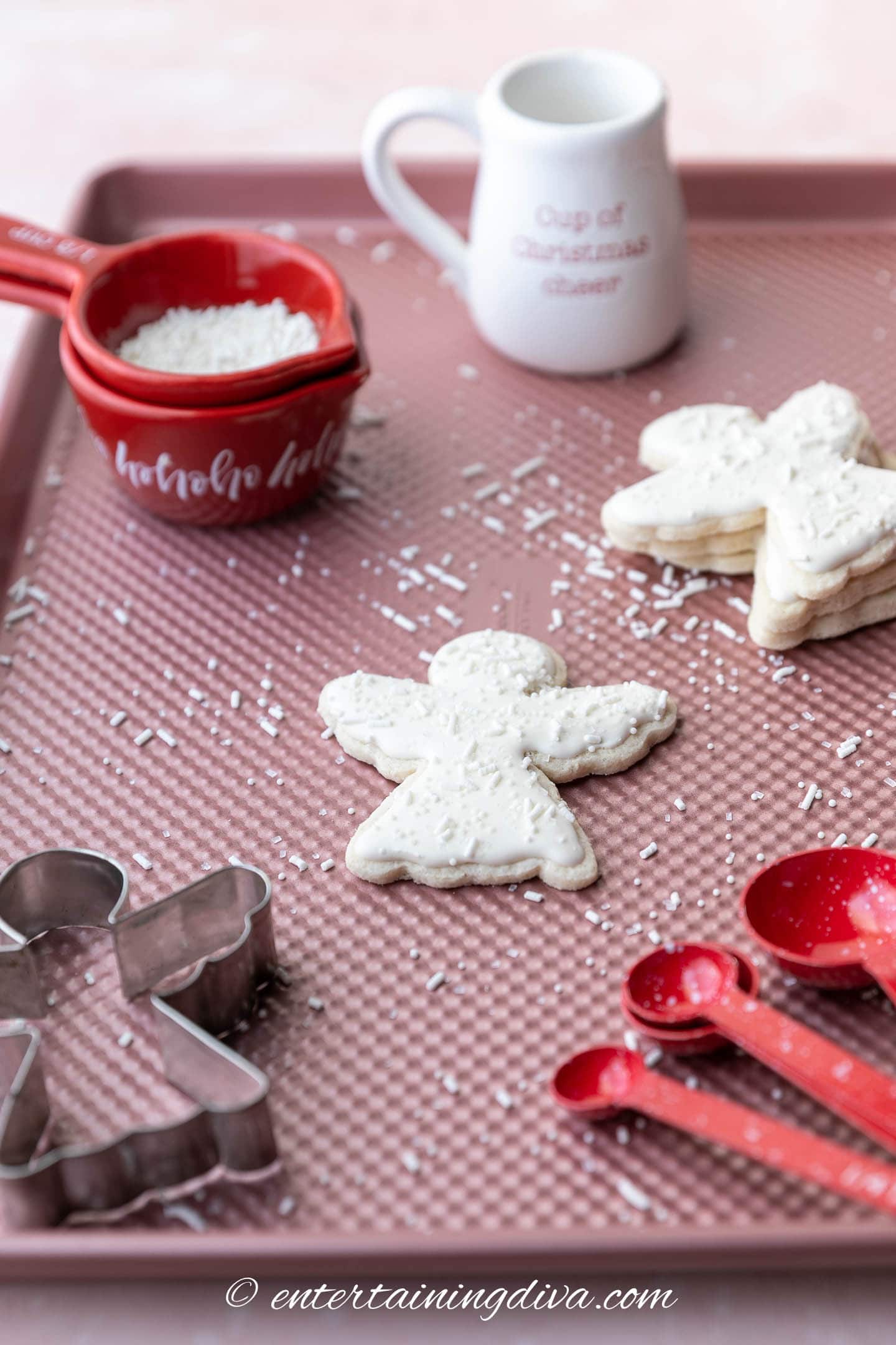 Decorated Christmas angel sugar cookies with an angel cookie cutter on a baking tray