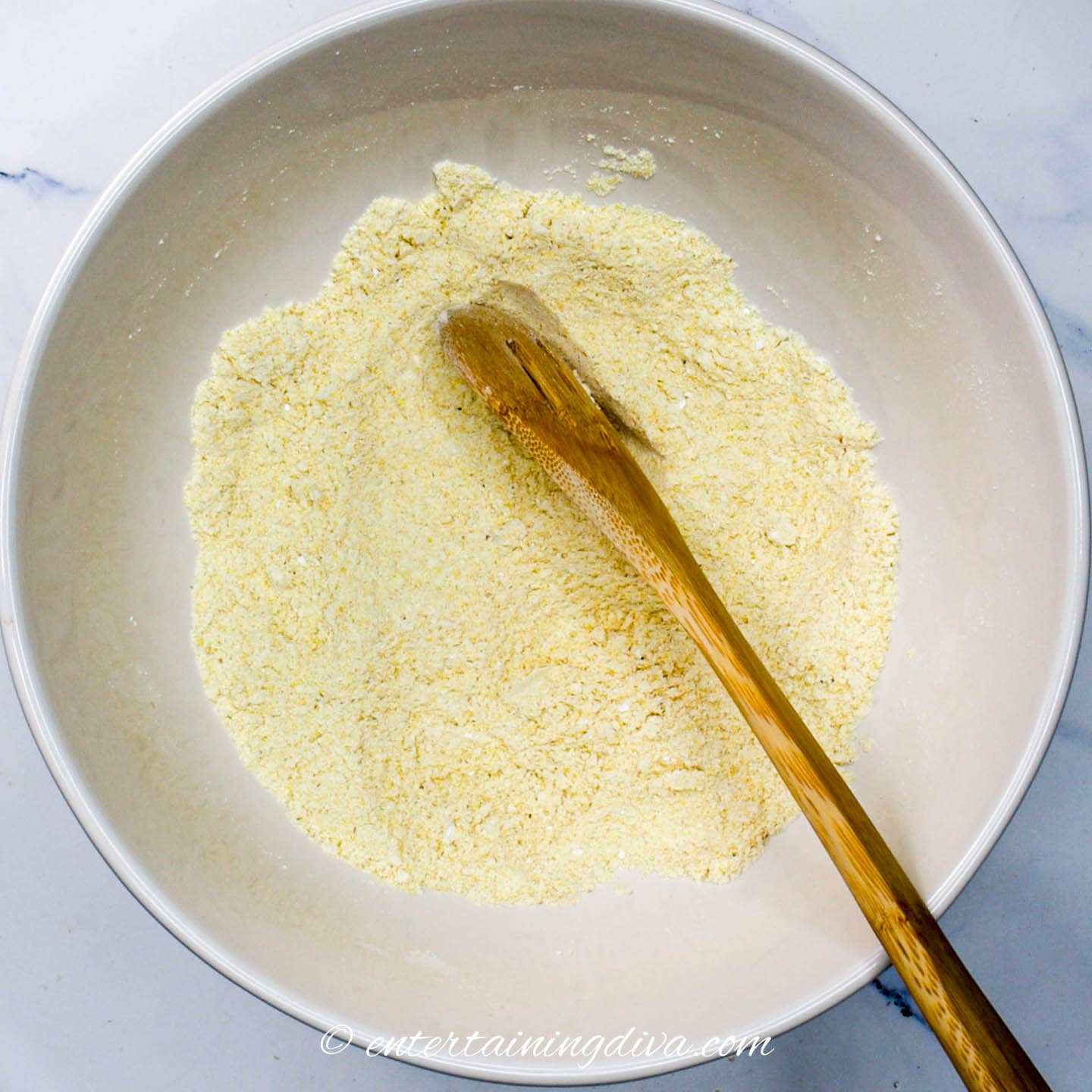 cornmeal and flour combined in a bowl with other dry ingredients