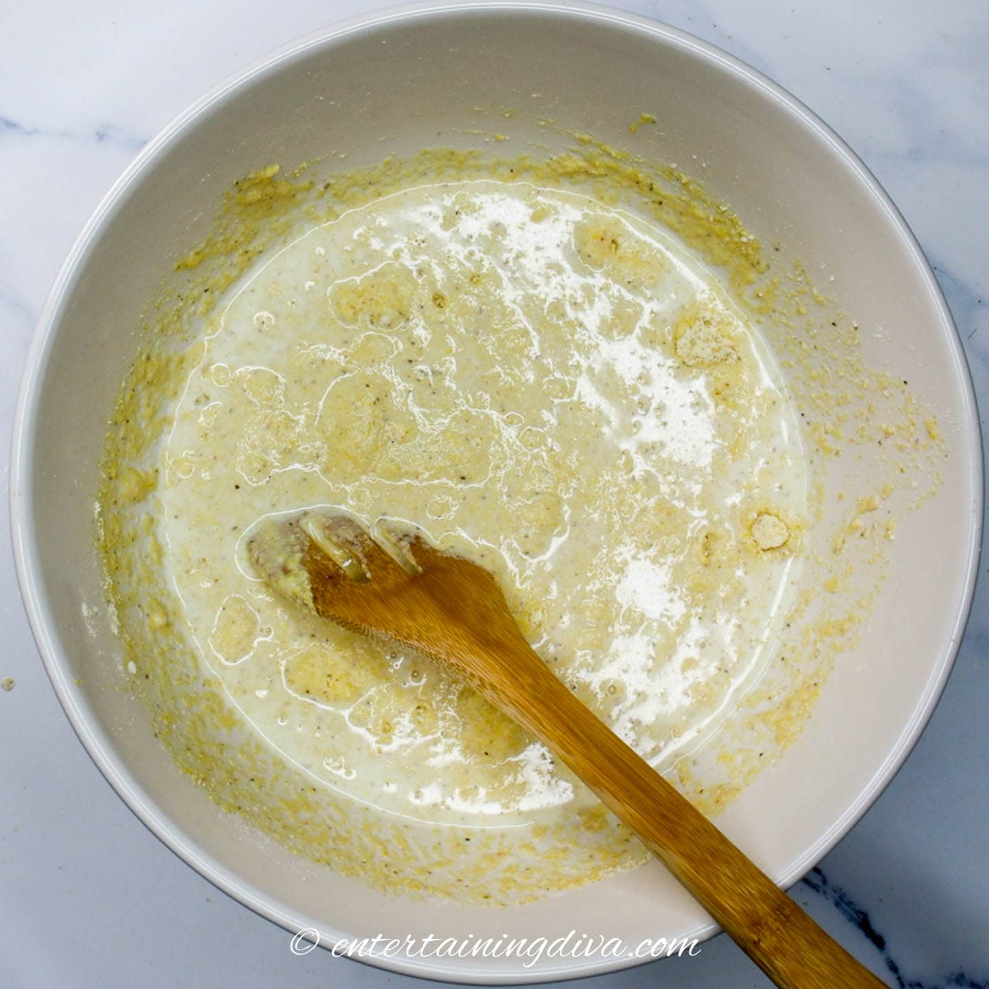cornbread wet ingredients mixed with dry ingredients in a bowl