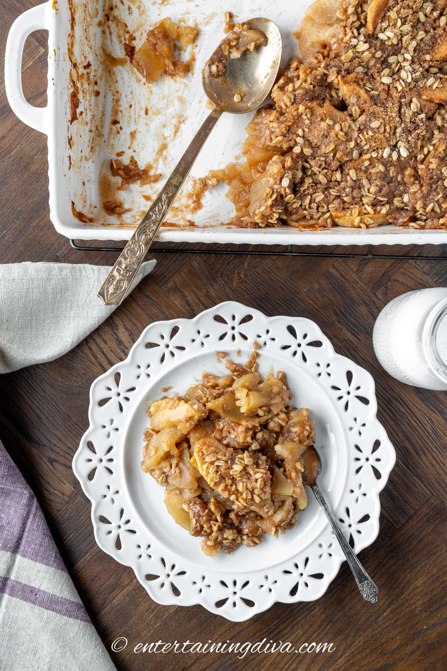 Apple oat crisp on a plate beside a baking dish with more apple crisp