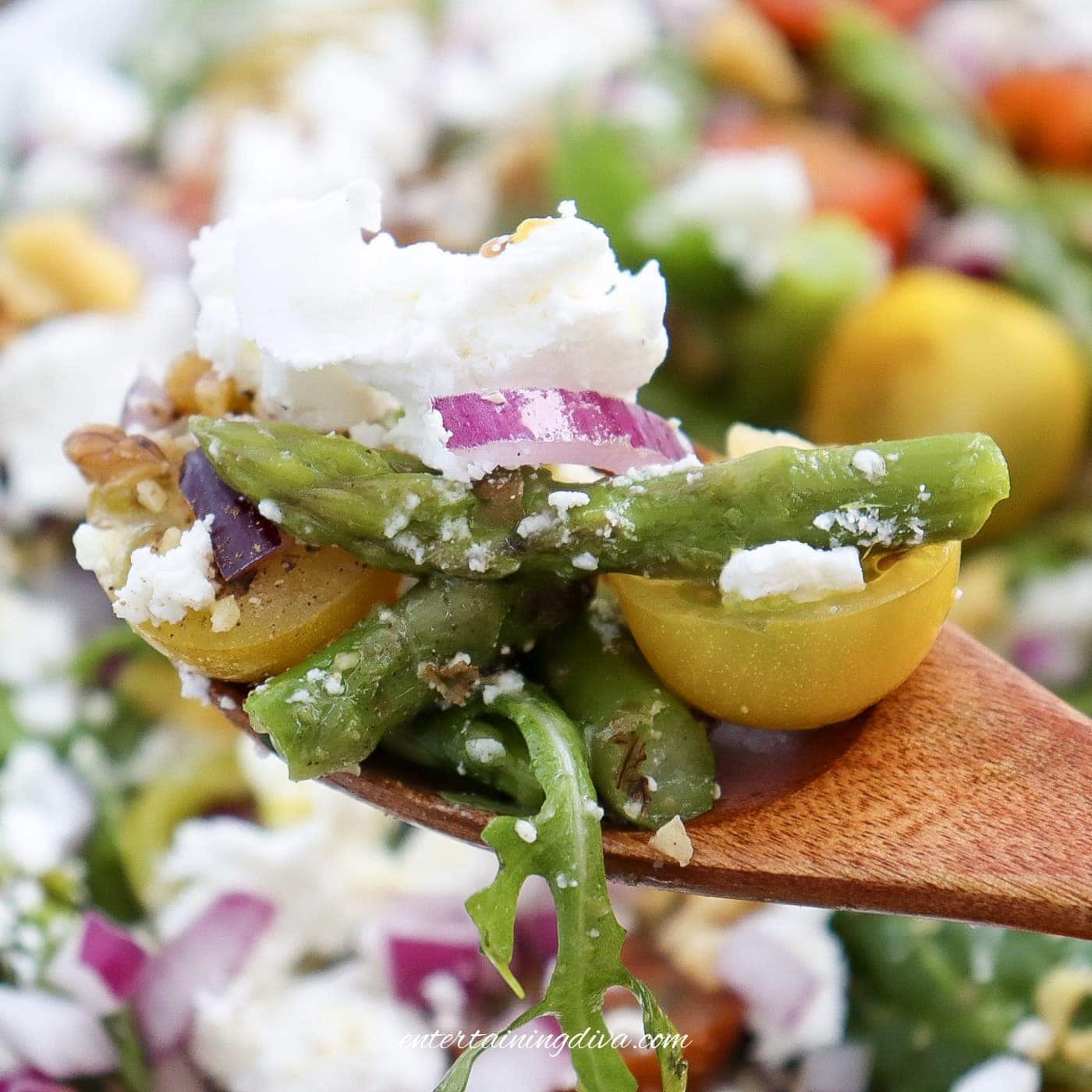 A close-up of fork full of asparagus goat cheese salad.