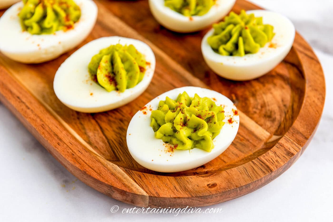 5 avocado deviled eggs on a tray