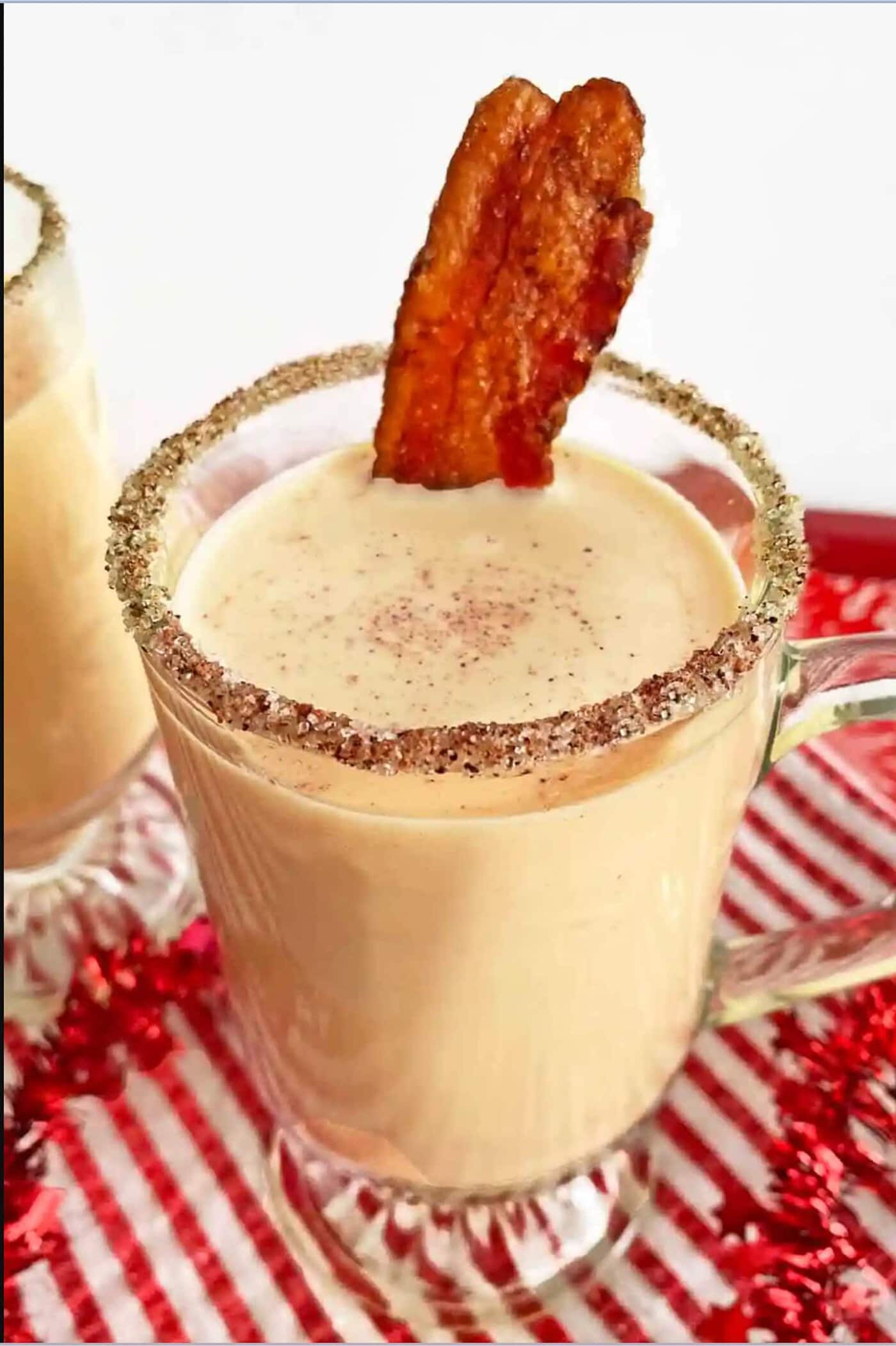 Two mugs with bacon and whipped cream in them.