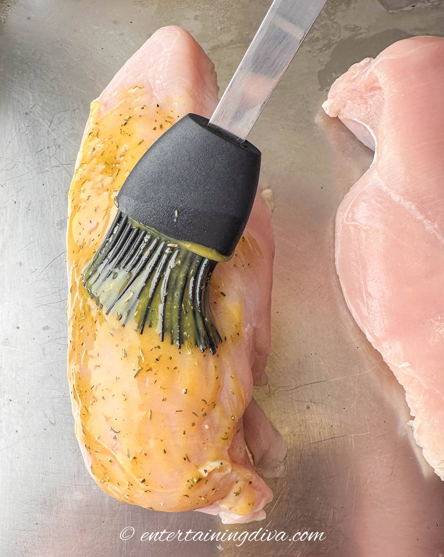 honey mustard sauce being brushed onto chicken breast