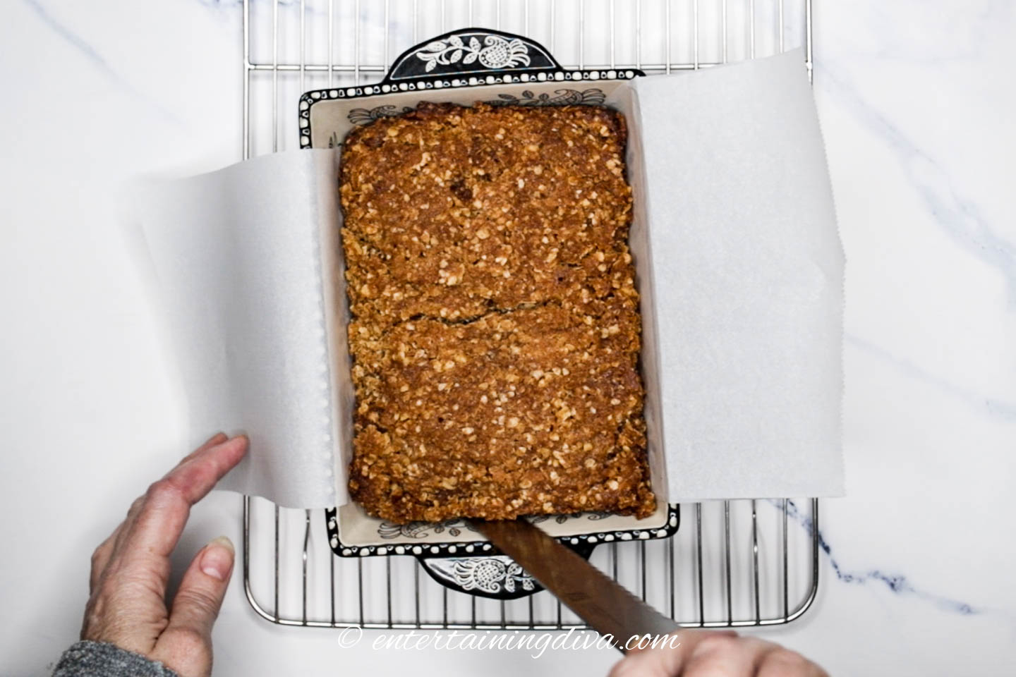 Knife cutting the sides of the banana nut bread in the pan