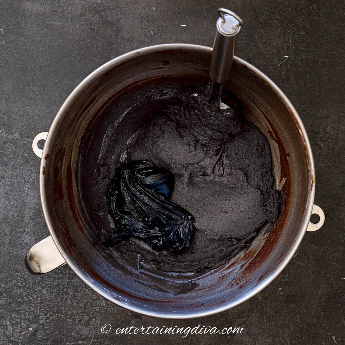 melted black frosting in a bowl with the chocolate buttercream frosting