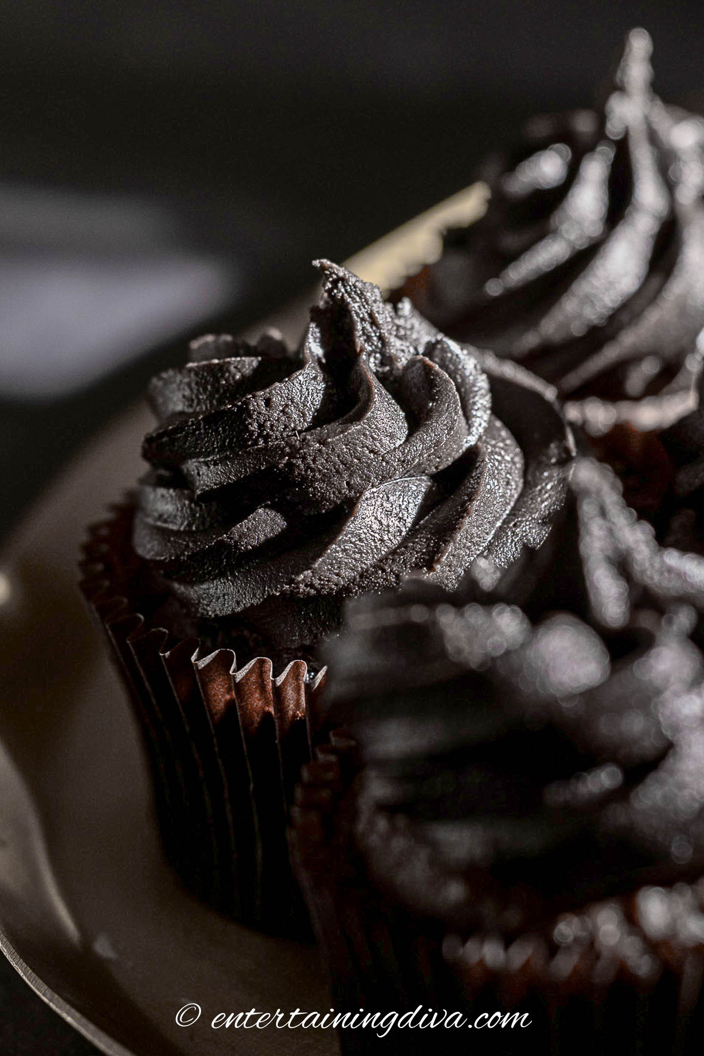 close up of black chocolate buttercream frosting on cupcakes