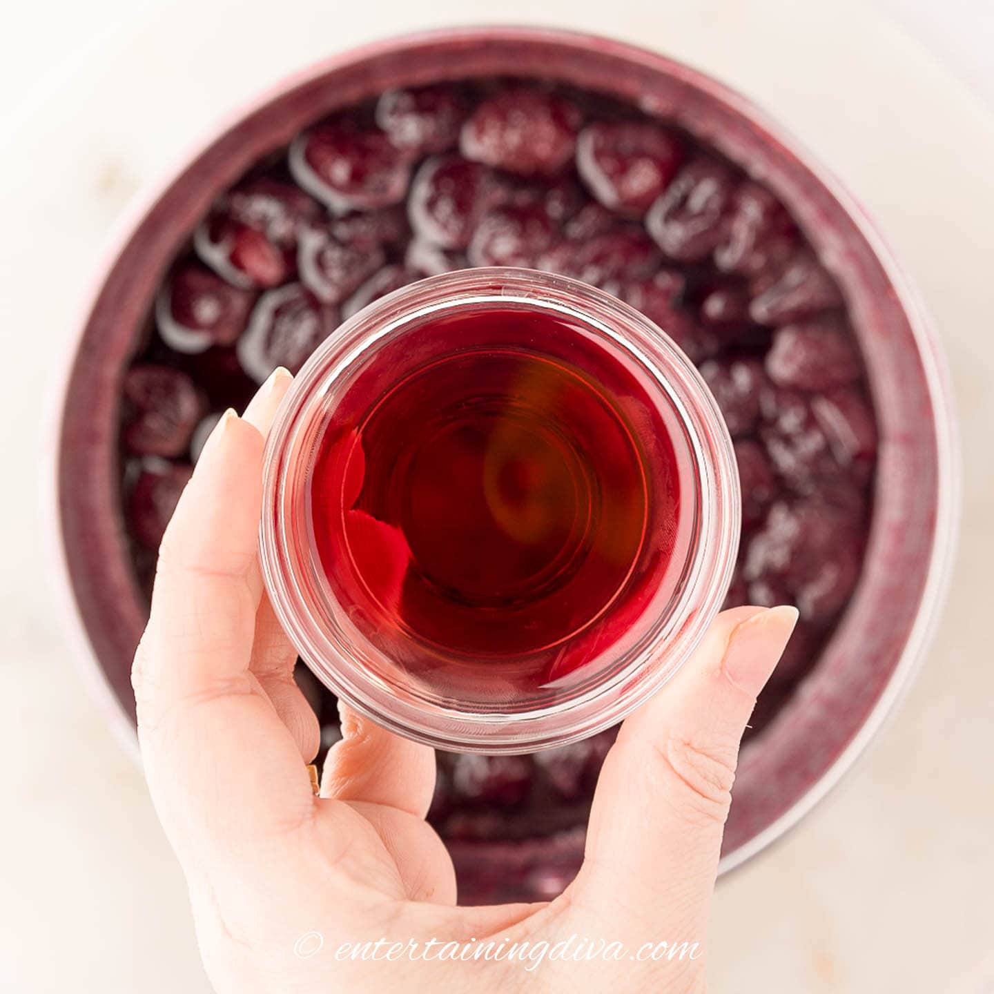 Kirsch being added to cherry compote in a sauce pan