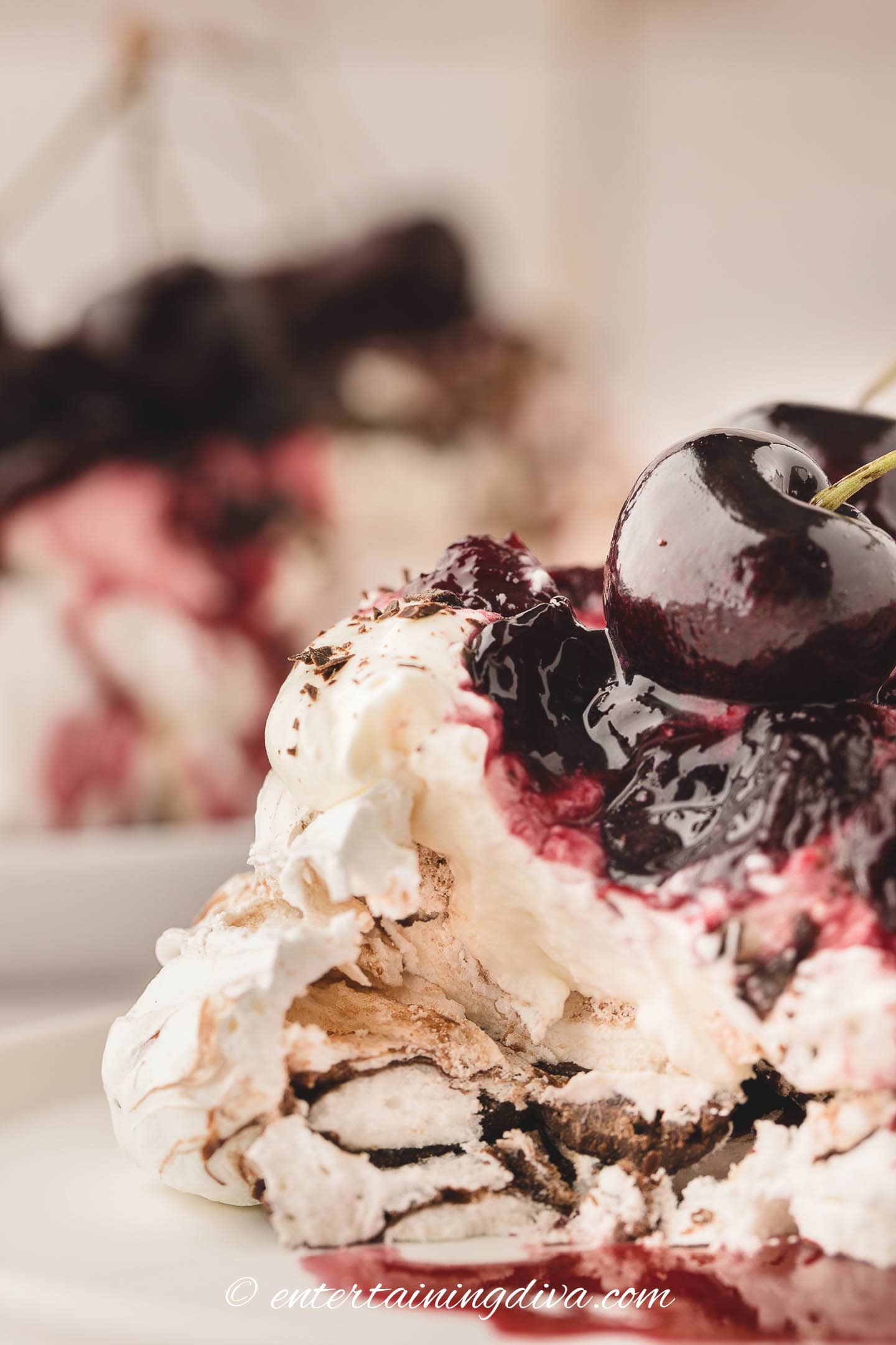 Close up of a black forest mini pavlova with a bite taken out of it