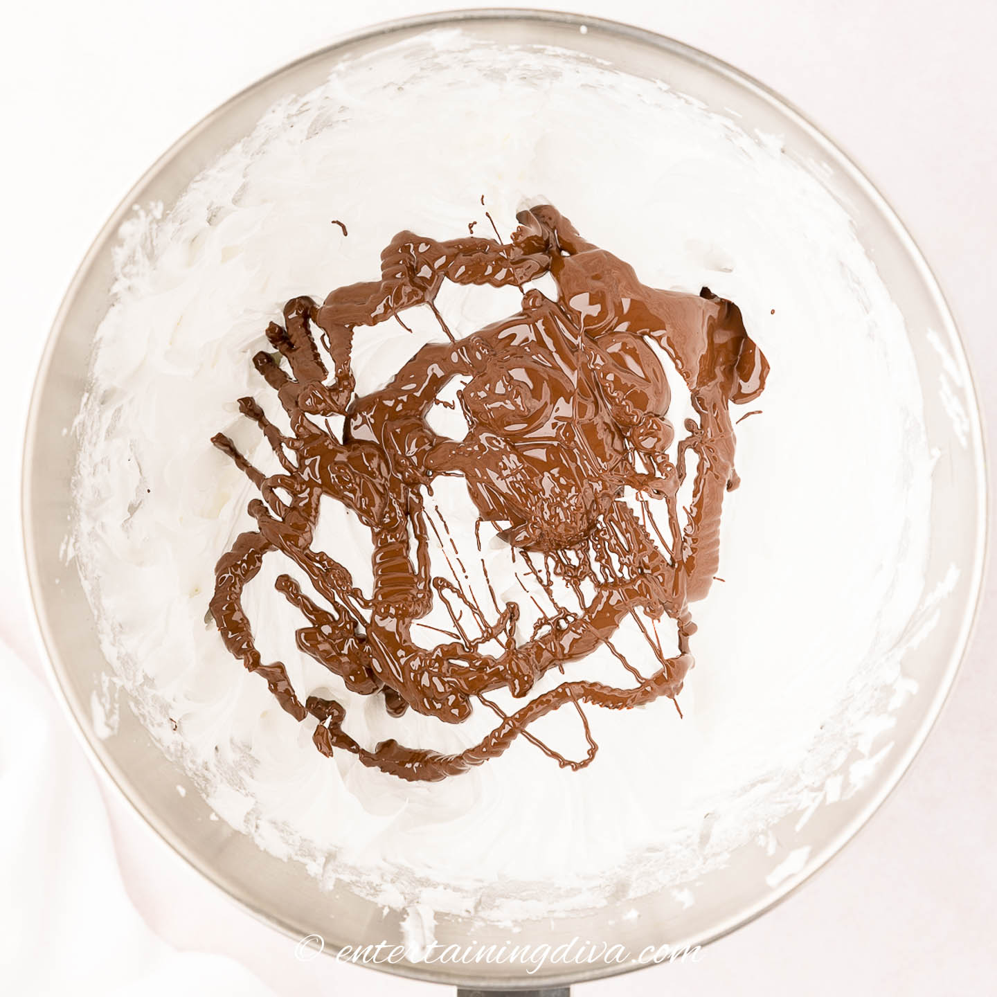 Whipped meringue mixture with melted chocolate in a bowl