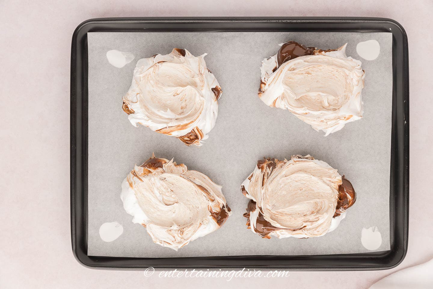 Dollops of meringue mixture on a baking sheet