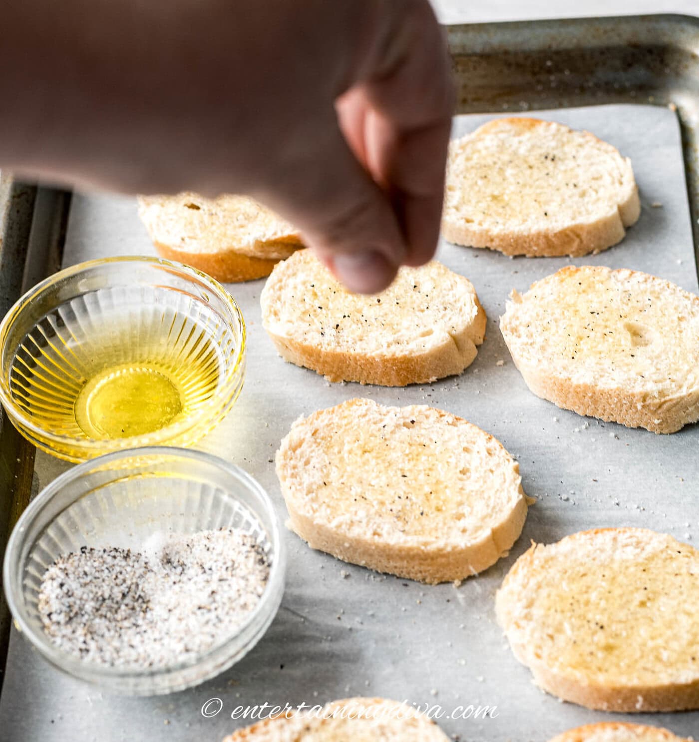 sprinkling salt and pepper on baguette slices