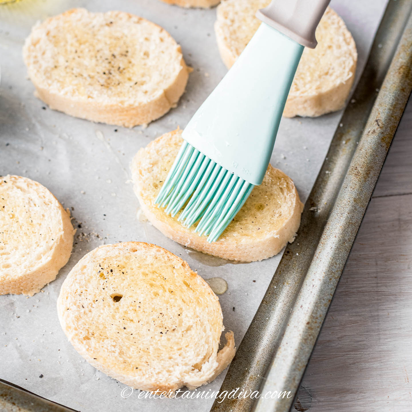brushing olive oil on baguette slices to make crostini