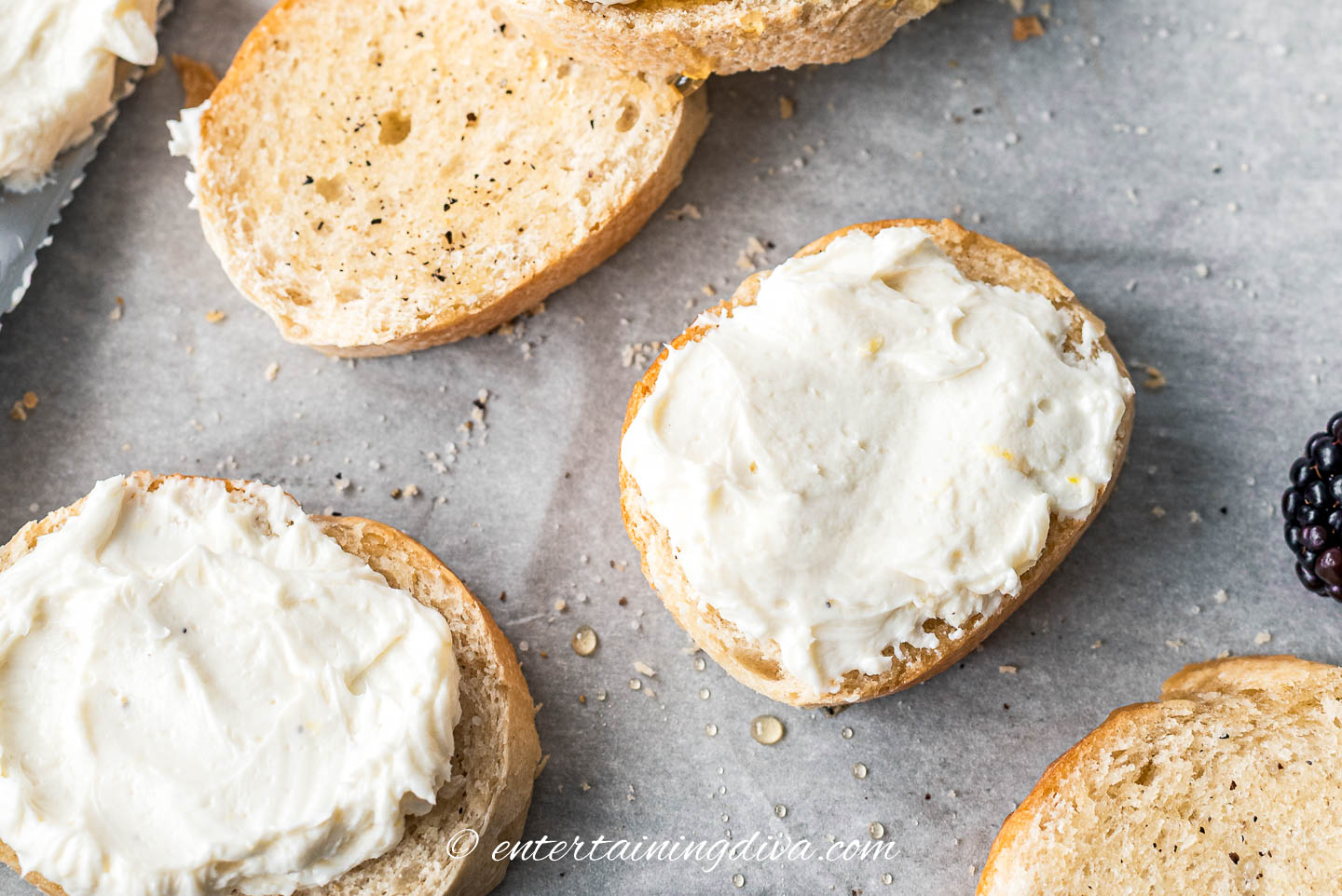 overhead of whipped goat cheese spread on crostini slices