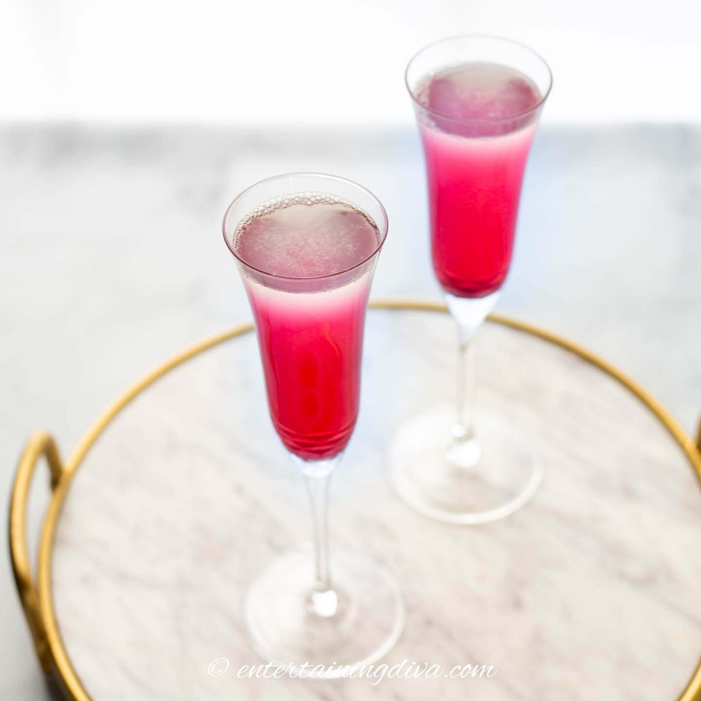 Two blueberry mimosas on a tray