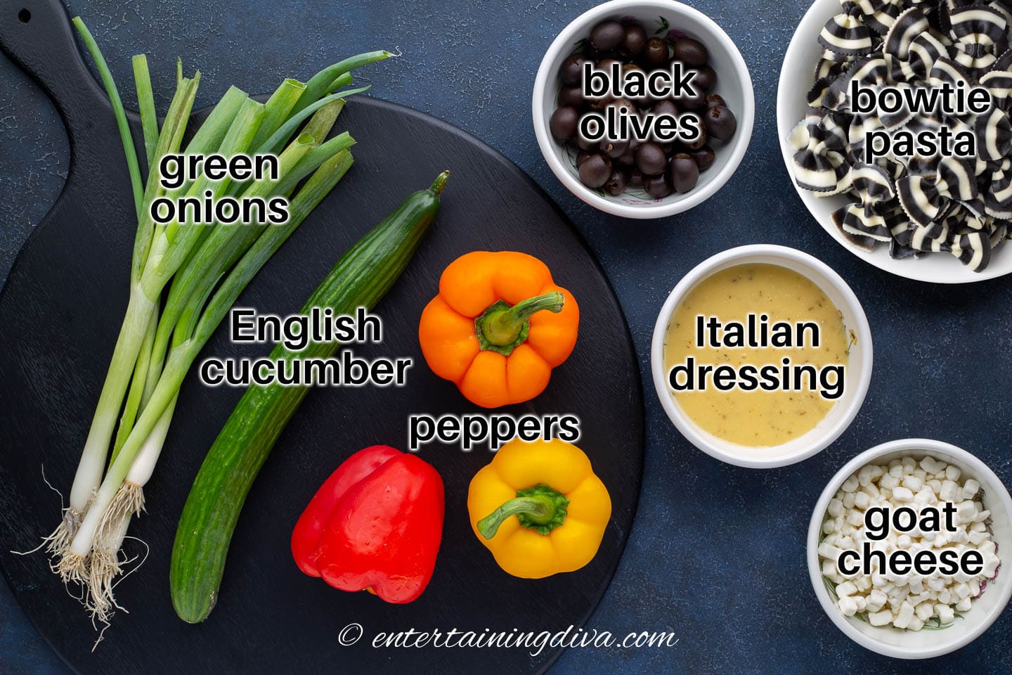 bow tie pasta salad ingredients - farfalle pasta, black olives, green onions, English cucumber, peppers, goat cheese and Italian dressing