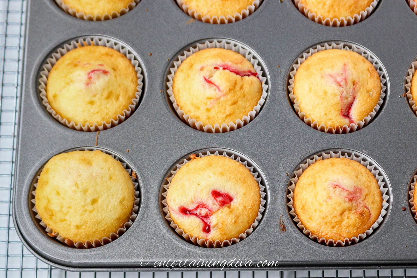 Baked white cupcakes with strawberry swirls