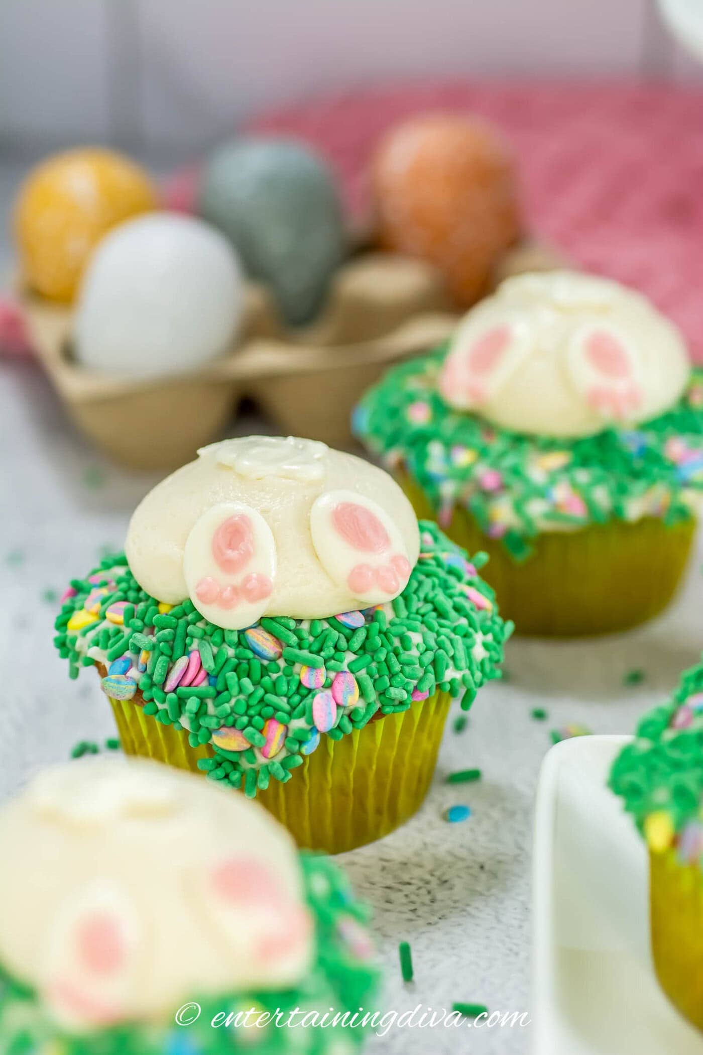 bunny butt cupcakes with Easter eggs in the background
