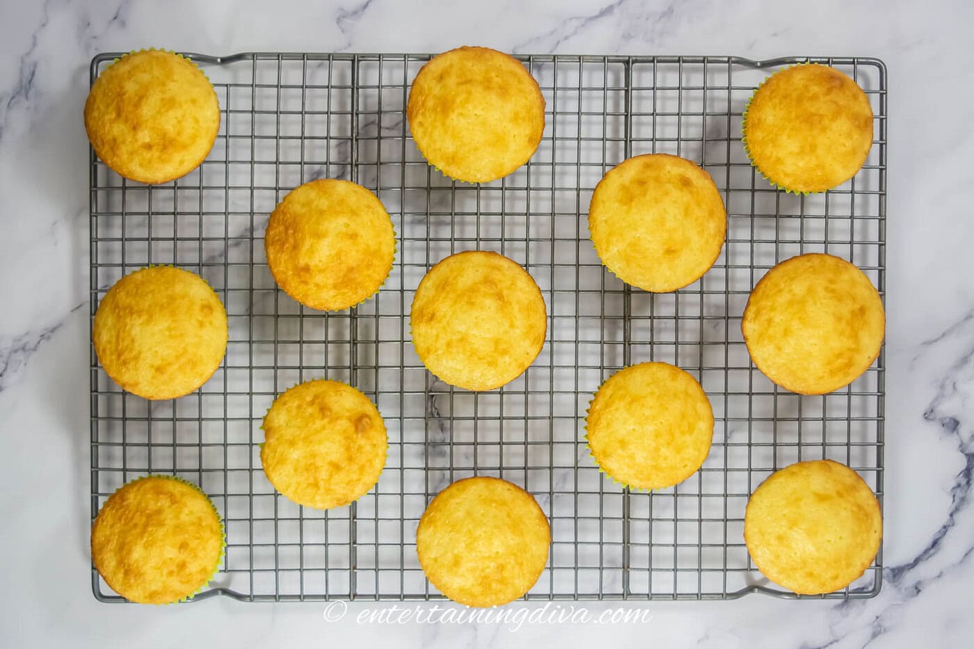 white cupcakes on a cooling rack
