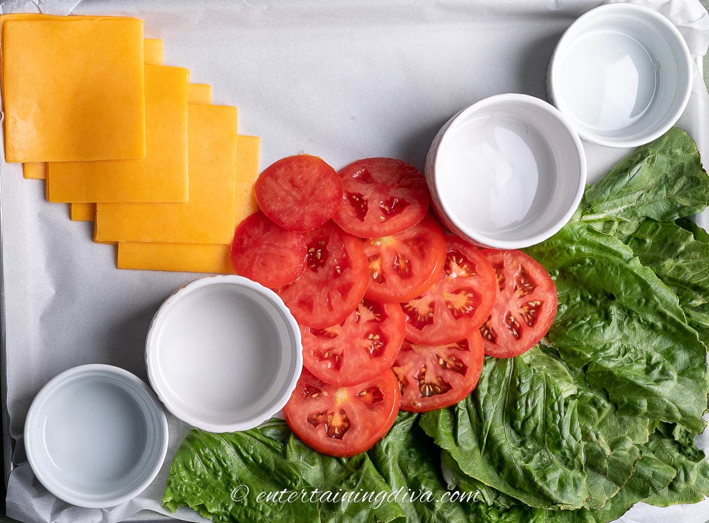 how to make a burger bar charcuterie board step 4: bowls, lettuce, cheese and tomatoes