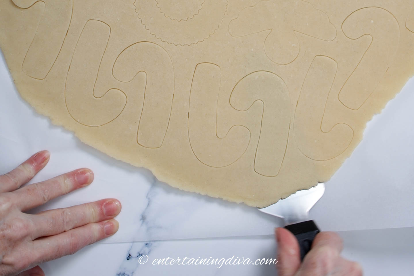 removing candy cane sugar cookies from the rolled out cookie dough