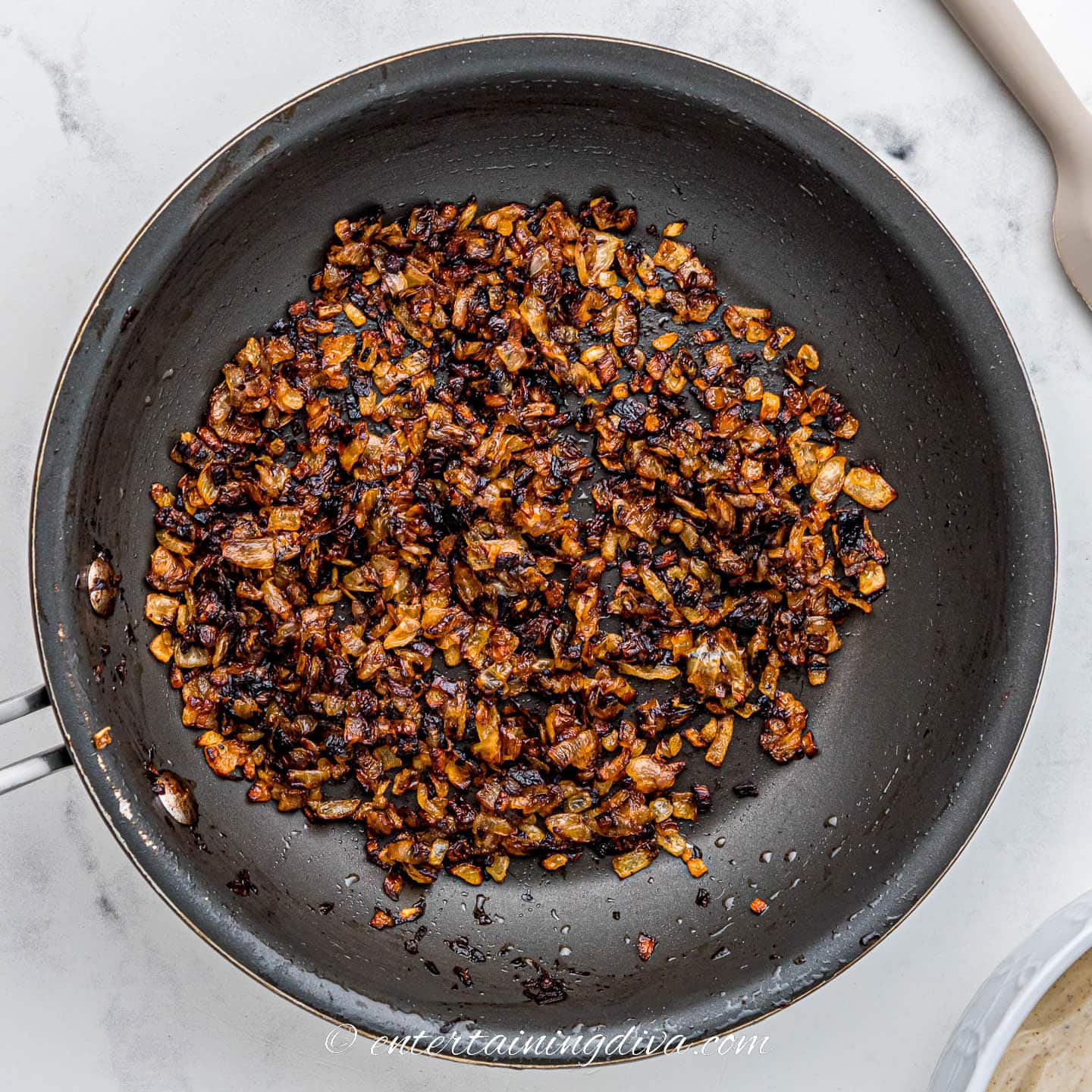 Caramelized chopped onions in a frying pan