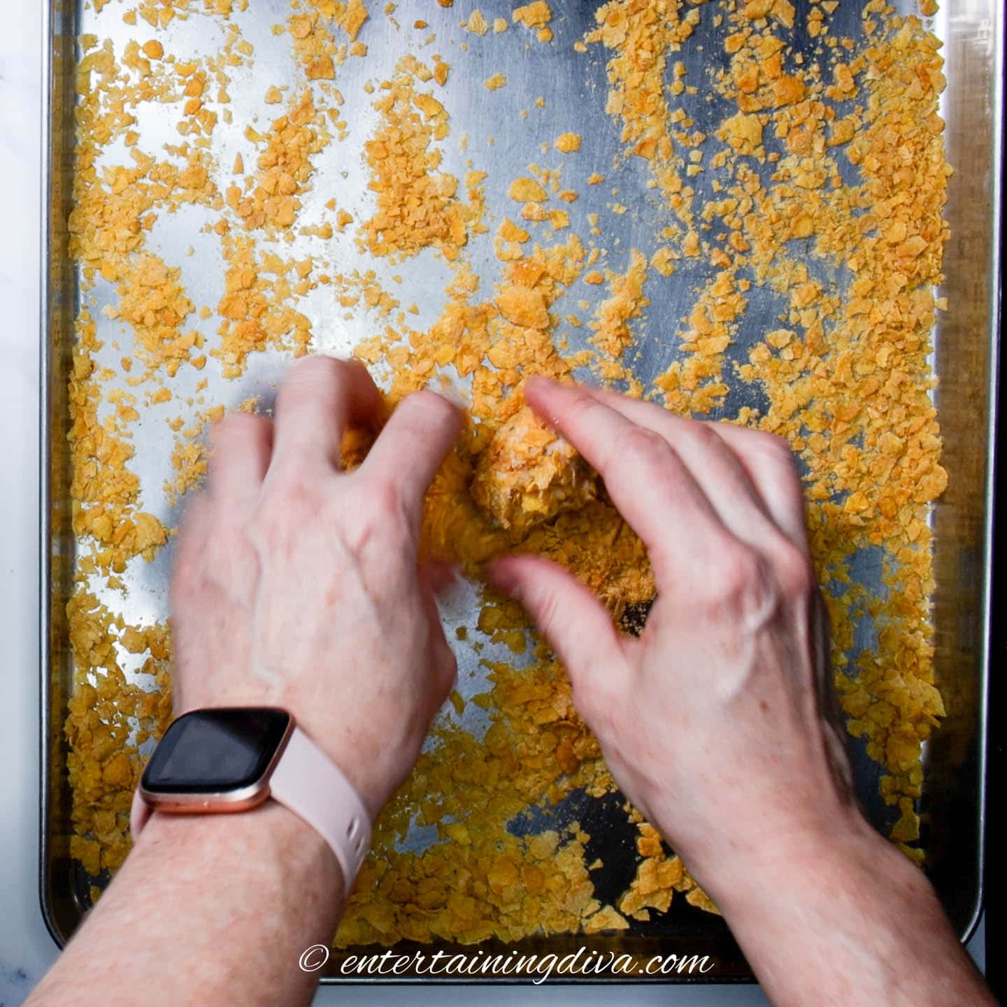 A cherry winks cookie being coated with cornflakes