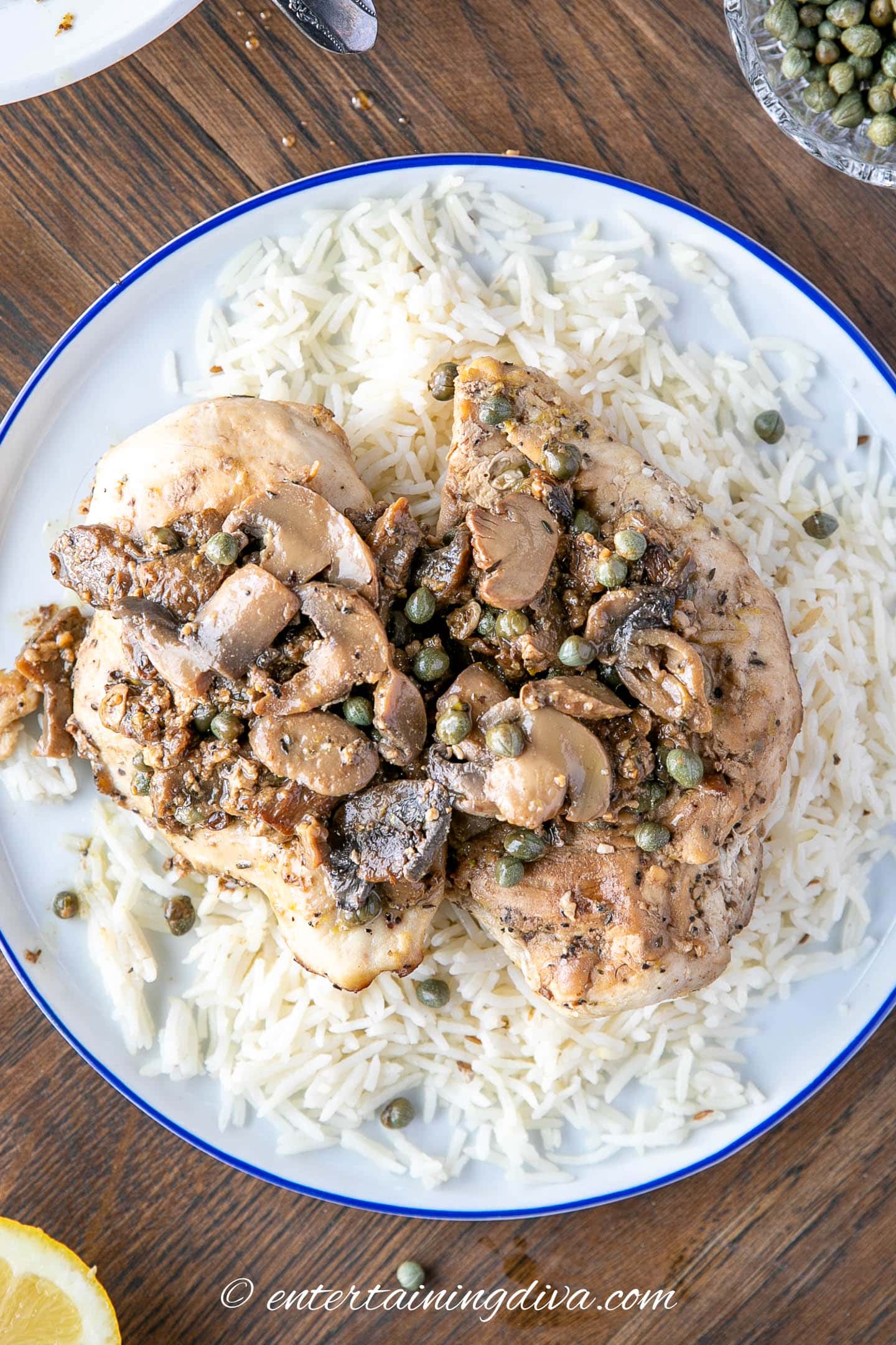 overhead picture of chicken piccata with mushrooms on a plate with rice