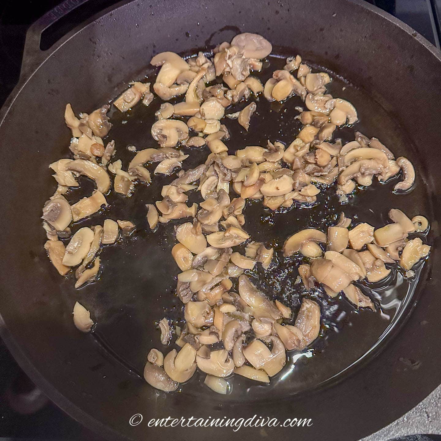 mushrooms cooking in a cast iron pan