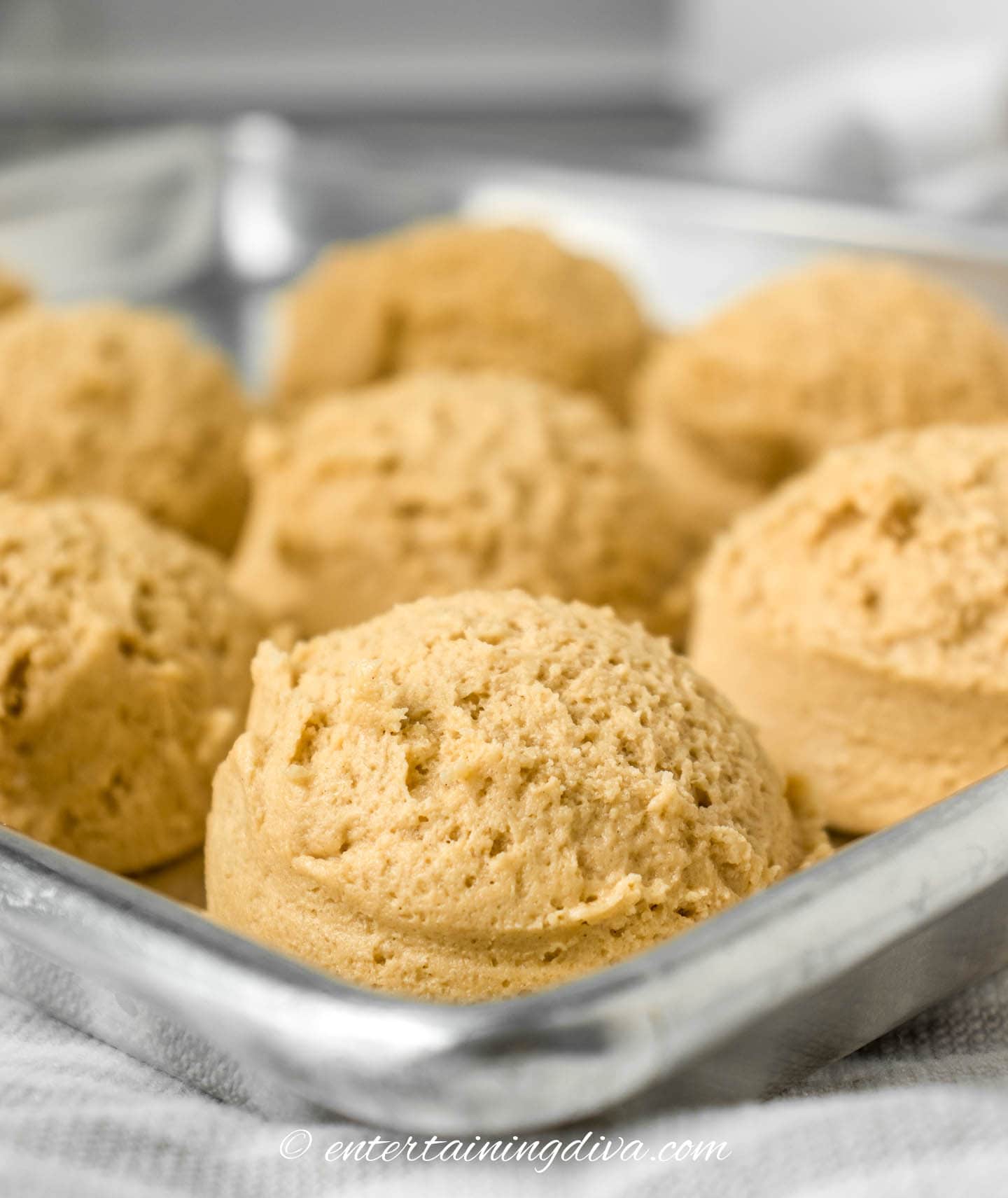 Chocolate dipped peanut butter cookies arranged in a baking pan.