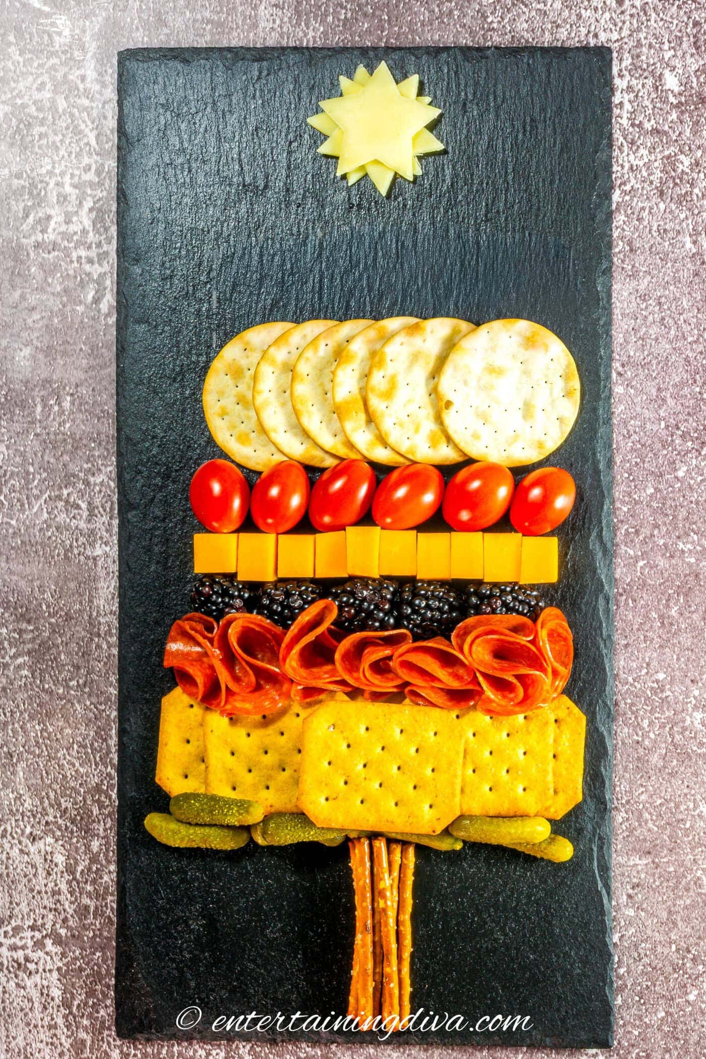 The Christmas tree charctuerie with the middle layers filled in on a black charcuterie board