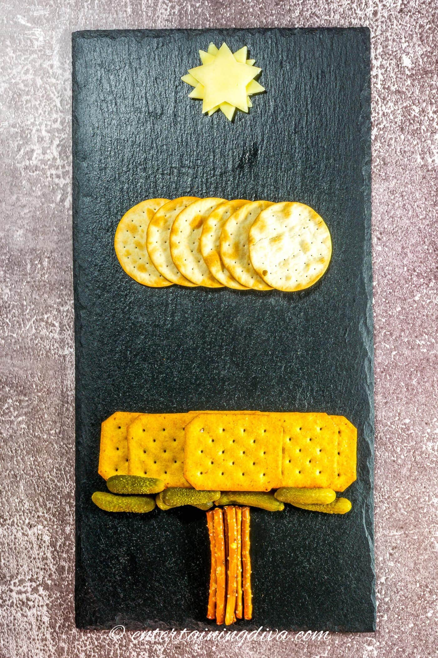 The first Christmas tree charctuerie layers on a black charcuterie board