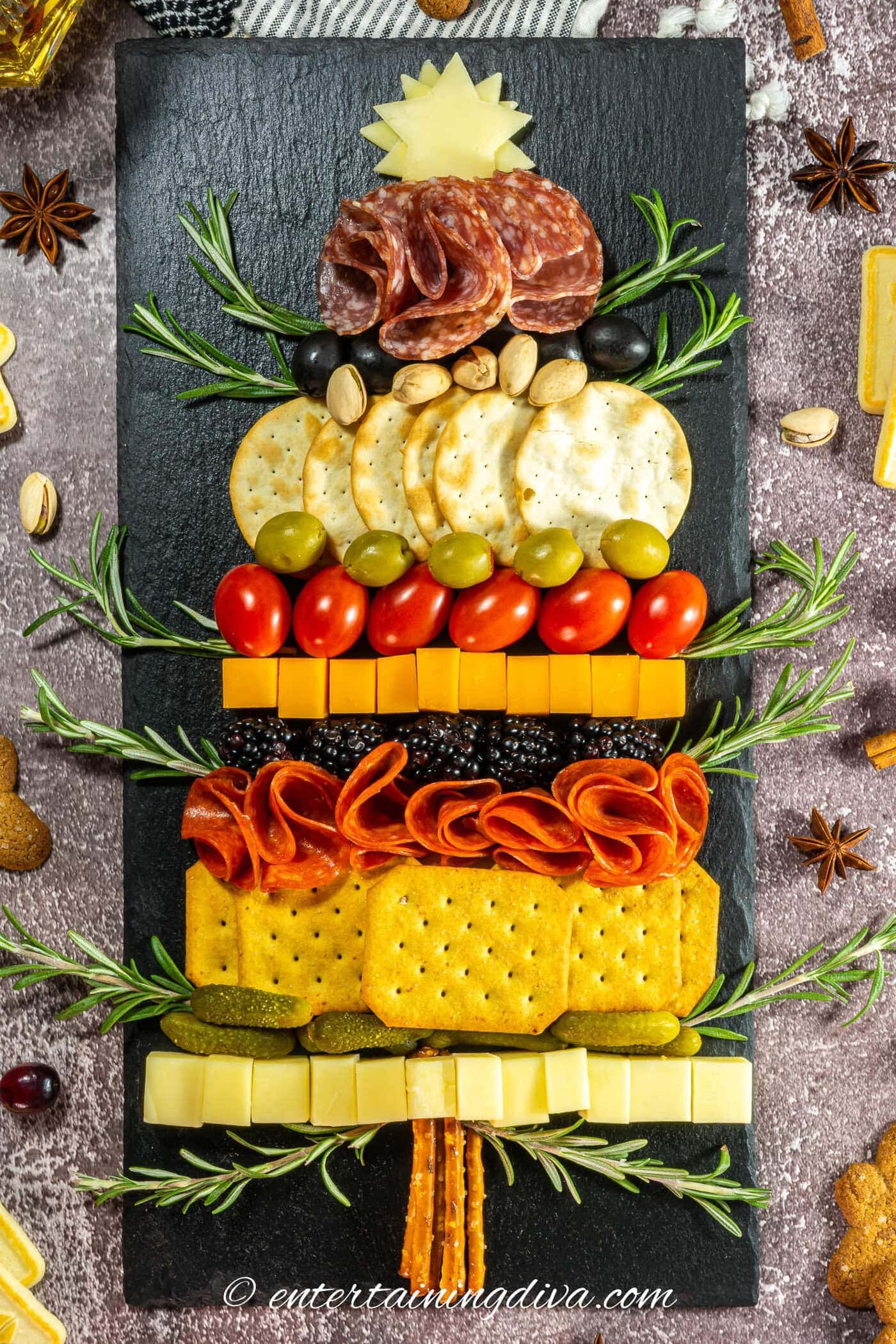 A Christmas tree charcuterie board surrounded by other Christmas ingredients