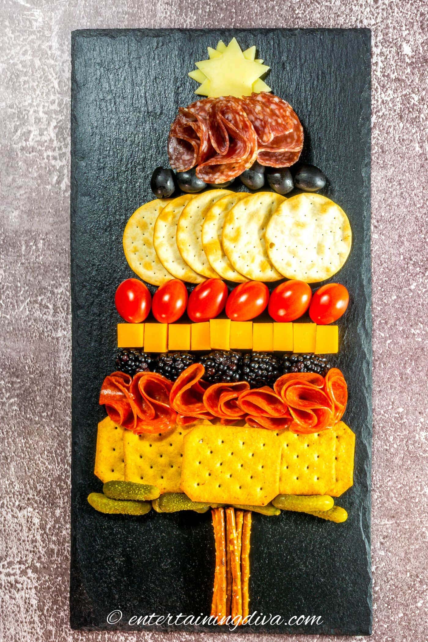 The Christmas tree charctuerie with the top layers on a black charcuterie board