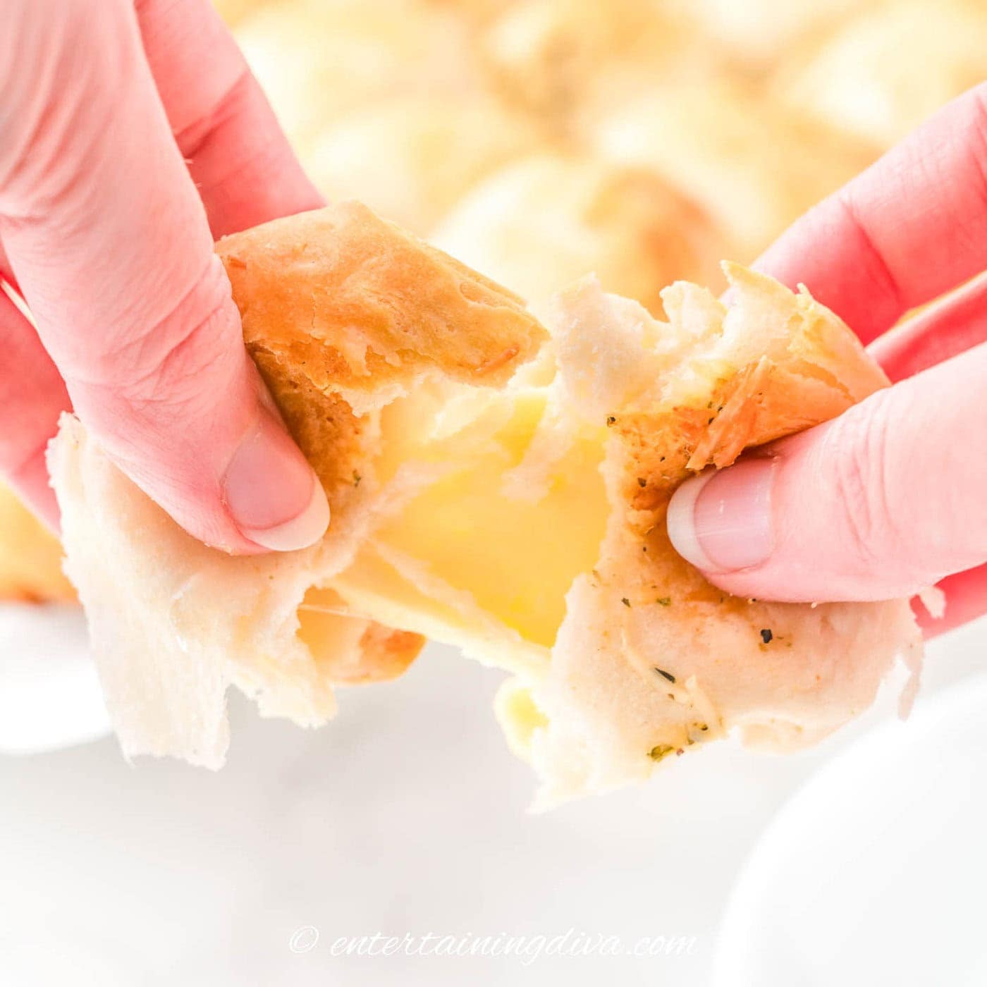 Close up of a cheesy dinner roll being pulled apart