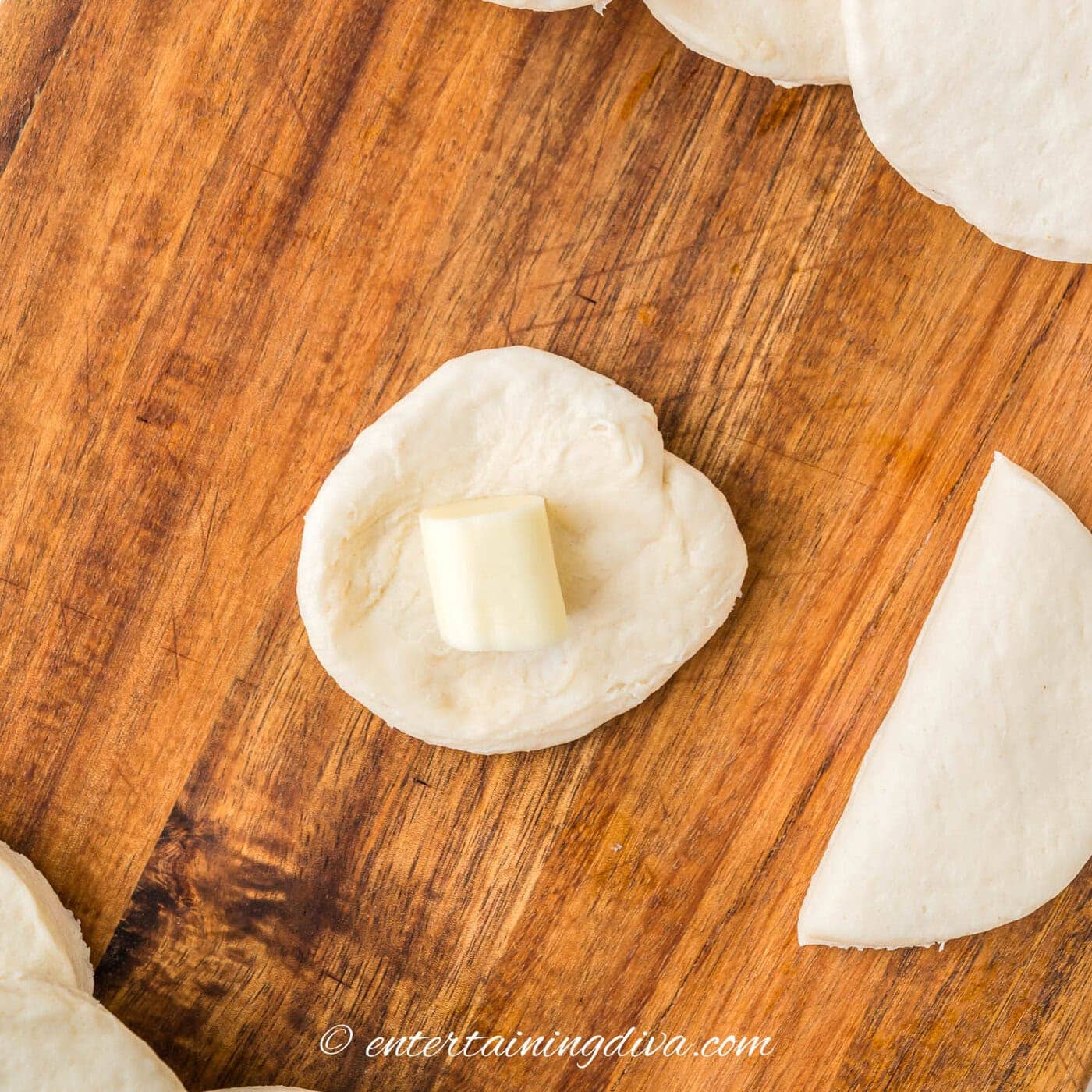 A piece of mozzarella on a circle of biscuit dough