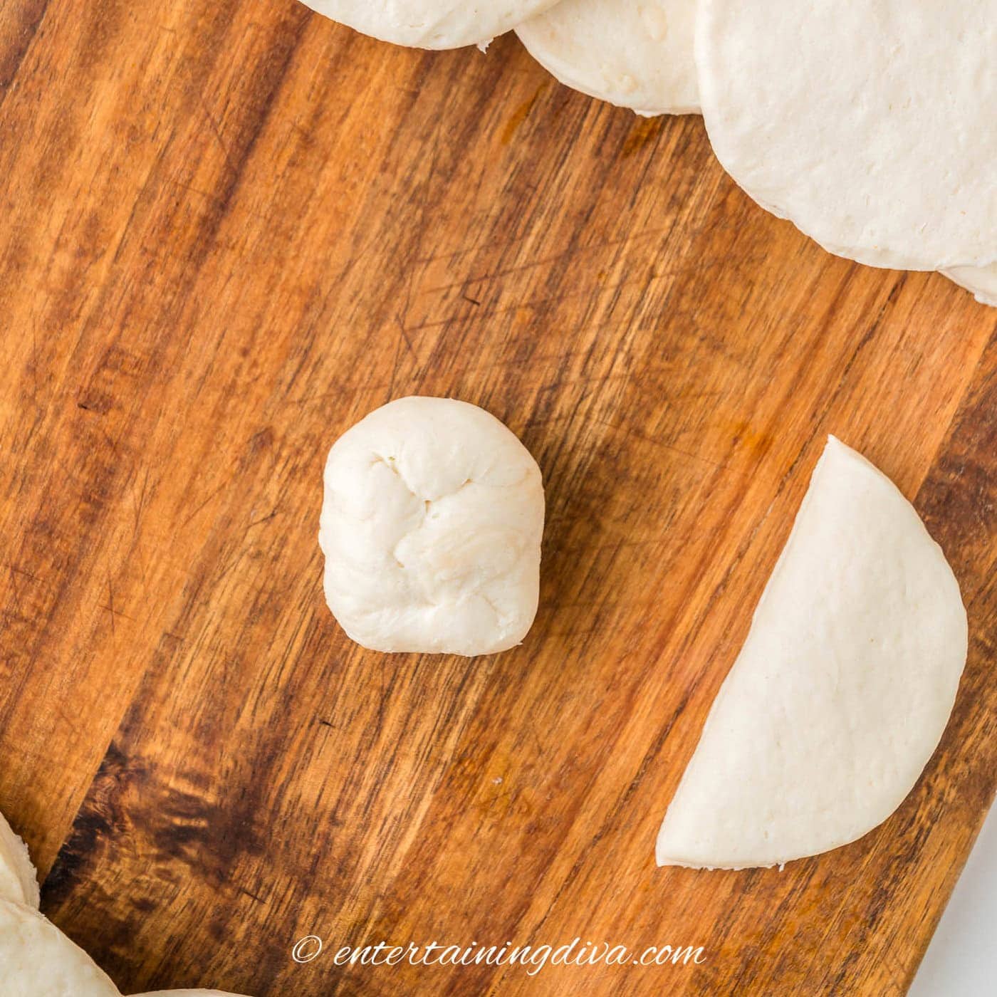 biscuit dough rolled into a ball with mozzarella in the middle