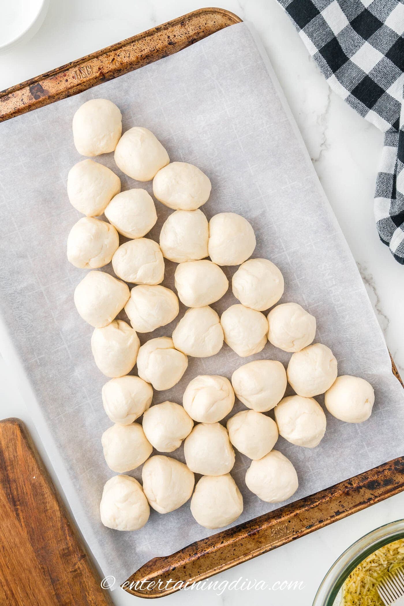 Uncooked rolls on a baking sheet arranged to look like a Christmas tree