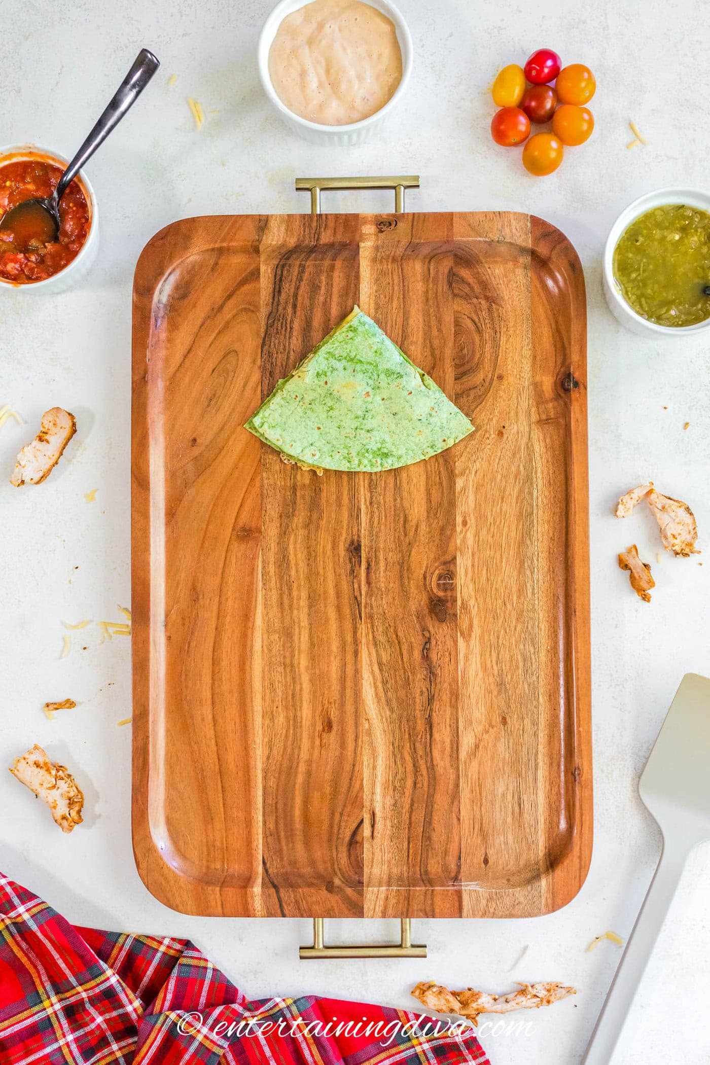One quarter of a quesadilla on a serving tray
