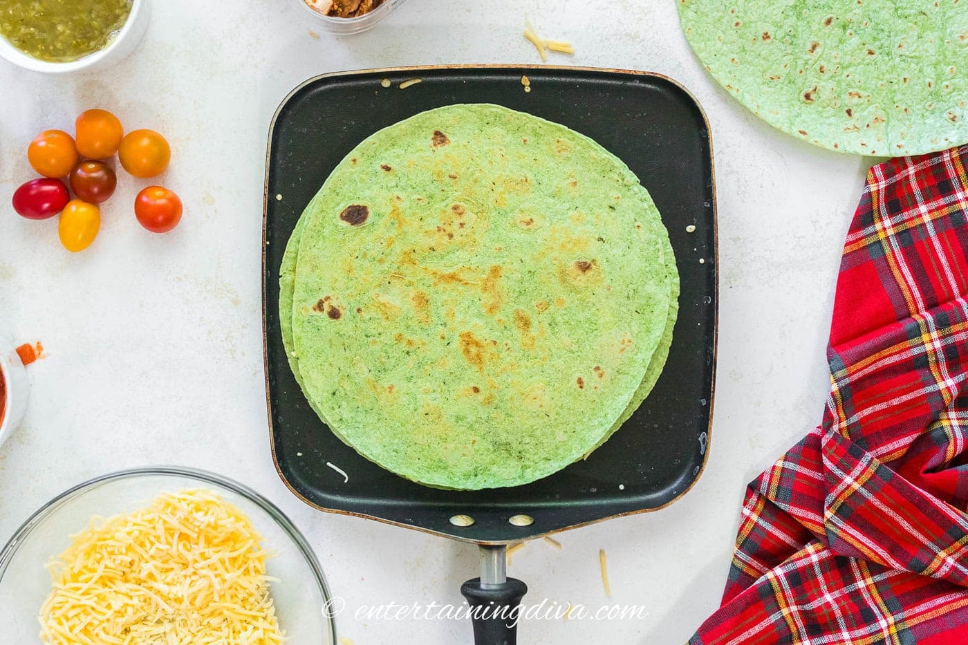 A spinach quesadilla cooking in a skillet