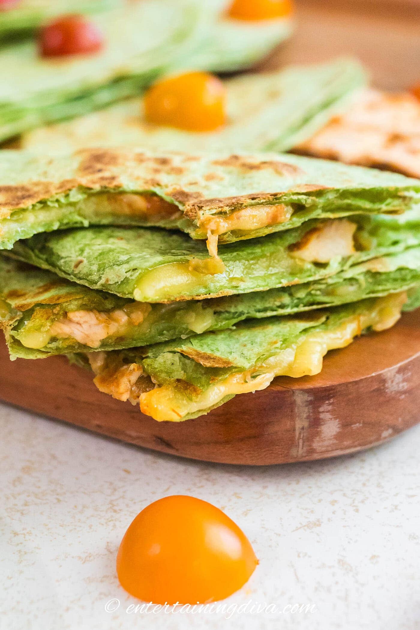 A close up of a stack of quesadillas with melted cheese dripping off the sides